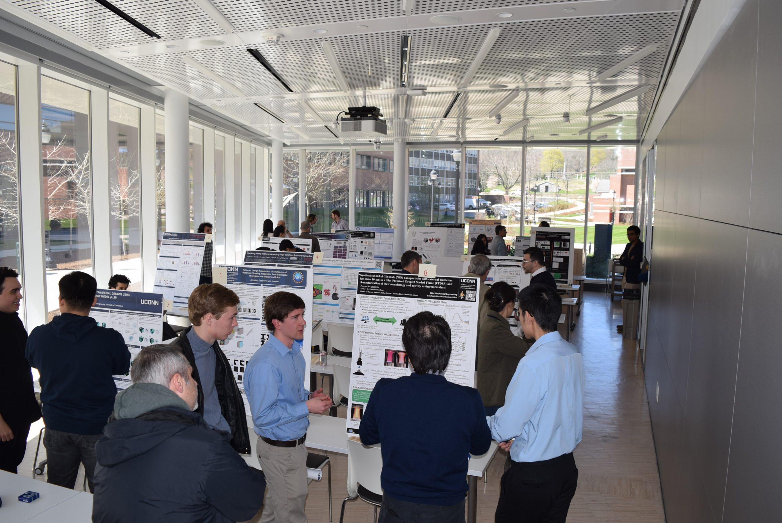 UConn mechanical engineering graduate student, Owen Fuhr, presents his research poster to judges Dr. Chang Liu and Dr. Ugur Pasaogullari during the annual ME Graduate Research Competition 